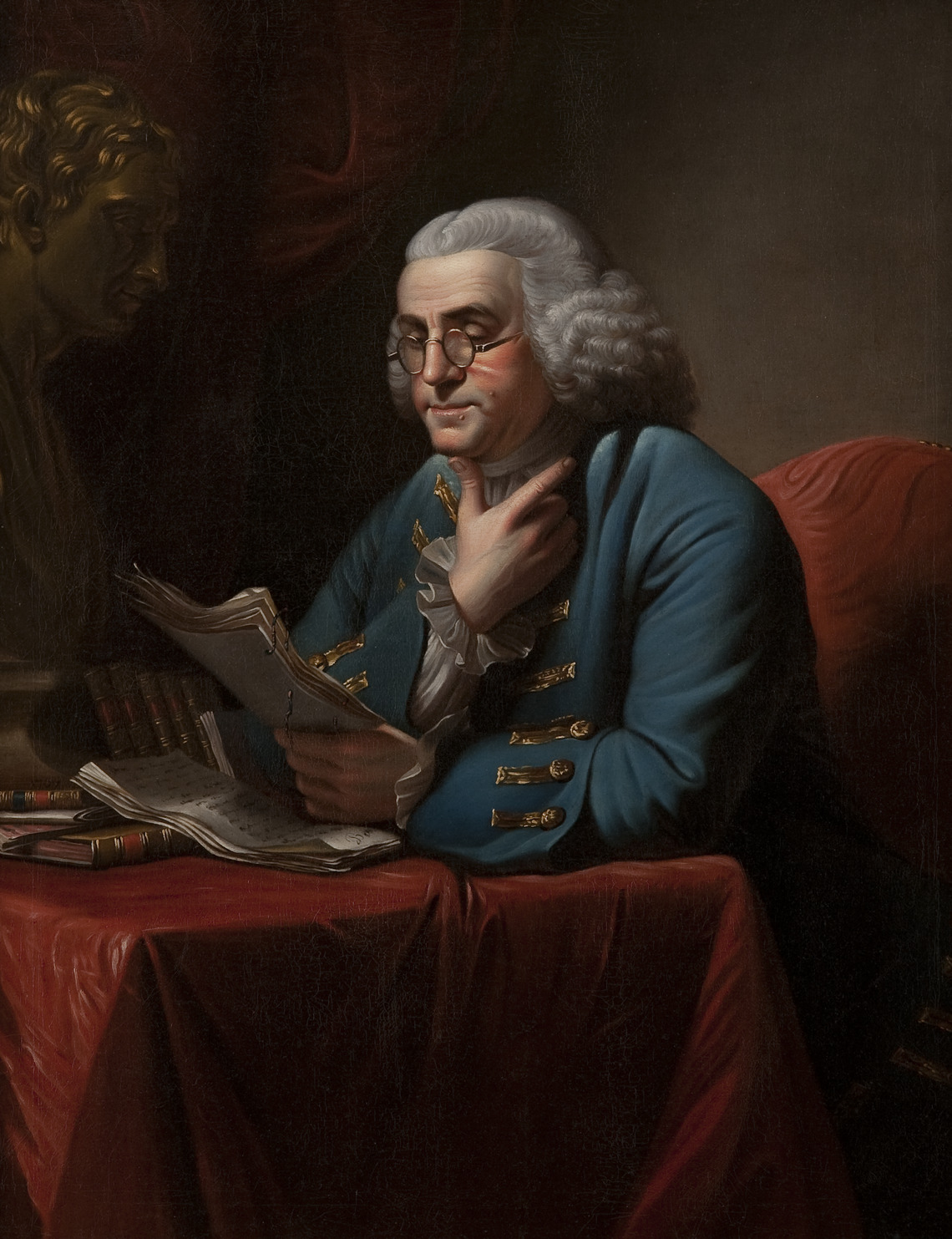An oil on canvas portrait of Benjamin Franklin, seated reading a manuscript document with his thumb balanced beneath his chin.